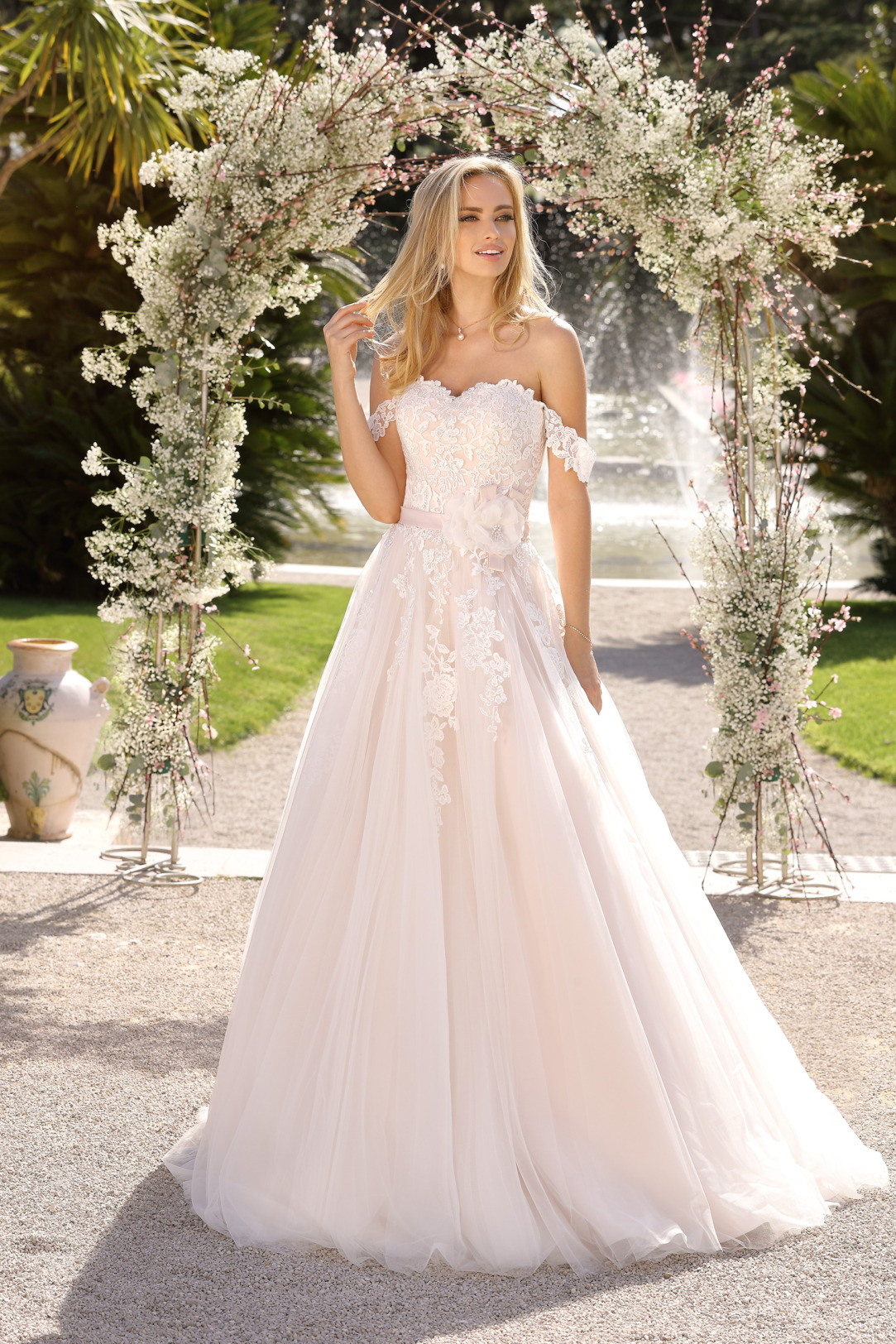 A-Linie Brautkleid mit überschnittener Schulter. Das schulterfrei getragene Hochzeitskleid in klassischer A Linie ist von Ladybird Modell 421028. Die feinsten Spitzenapplikationen am Oberteil verleihen diesem Brautkleid seinen romantischen Look. Das Corsagen-Brautkleid mit off Shoulder-Trägern ist ein zauberhafter Blickfang